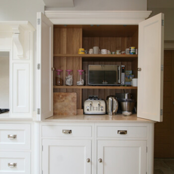 Petite Pantry Painted with pine storage sledges to rear of doors and four wicker baskets. Knights Country Kitchens